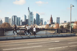 Runners on city bridge pavement 