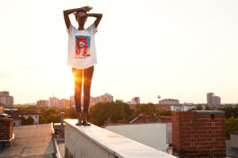 Woman on rooftop edge at sunset 